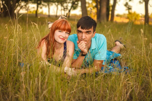 Casal deitado ao lado um do outro em um prado, ao ar livre — Fotografia de Stock