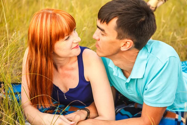 Casal deitado ao lado um do outro em um prado, ao ar livre — Fotografia de Stock