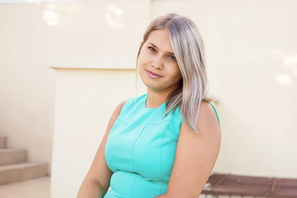 Hermosa chica en un vestido de color turquesa posando en la escalera, al aire libre —  Fotos de Stock