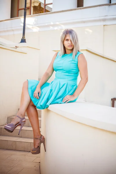 Hermosa chica en un vestido de color turquesa posando en la escalera, al aire libre —  Fotos de Stock