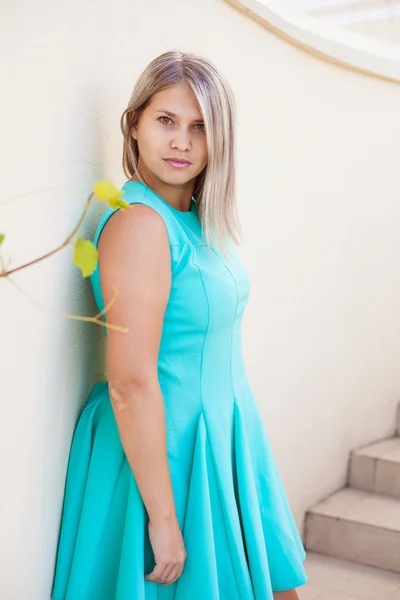 Hermosa chica en un vestido de color turquesa posando en la escalera, al aire libre —  Fotos de Stock