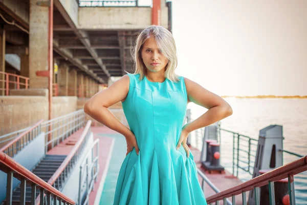 Hermosa chica en un vestido de color turquesa posando en la calle; outdoo —  Fotos de Stock