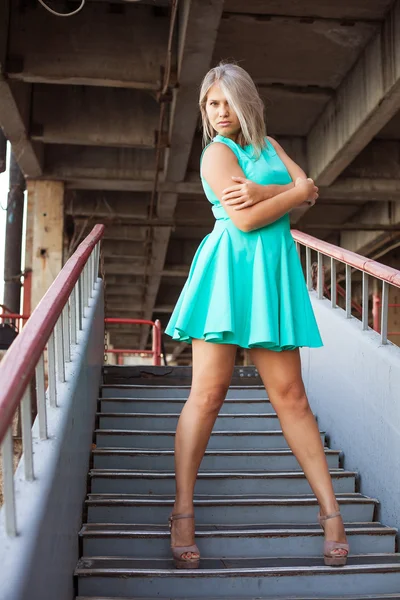 Hermosa chica en un vestido de color turquesa posando en la calle; outdoo —  Fotos de Stock