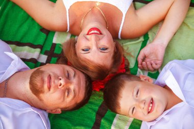 Anne baba ve oğul halıya baş üstten görünüm yalan