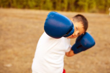 Boks eldivenleri ormanda açık havada poz çocukla