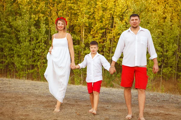 Anne baba ve oğul ormanın içinden el ele yürüyüş — Stok fotoğraf