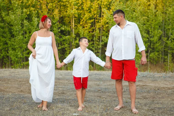 Mãe pai e filho andando pela floresta de mãos dadas — Fotografia de Stock