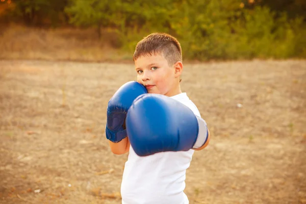 Pojke med boxhandskar poserar i skogen utomhus — Stockfoto