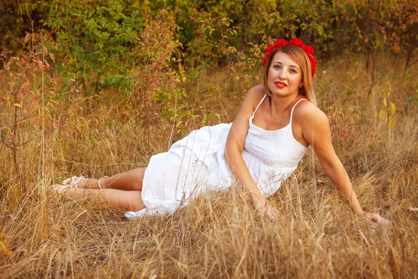 Schöne junge Frau posiert im Gras liegend im Freien — Stockfoto