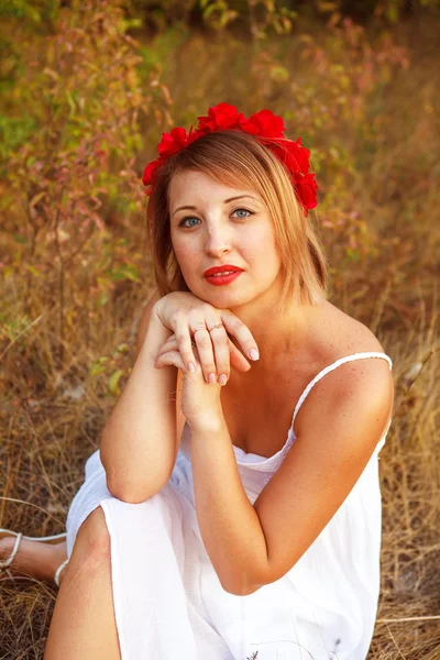 Hermosa mujer posando sentada en un campo; al aire libre — Foto de Stock