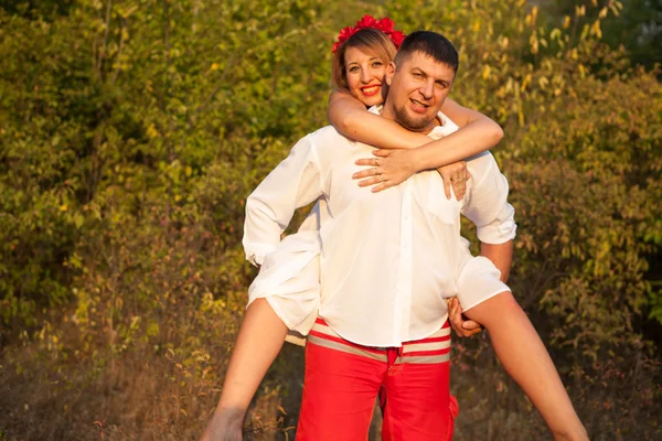 Woman on the shoulders of men. A couple on a walk in the park — Stock Photo, Image