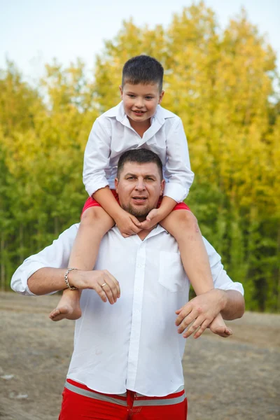 His son on the shoulders of his father for a walk in the park — Stock Photo, Image