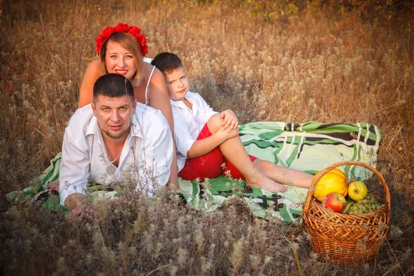 Mãe pai e filho deitado no tapete ao lado um do outro no parque ou — Fotografia de Stock