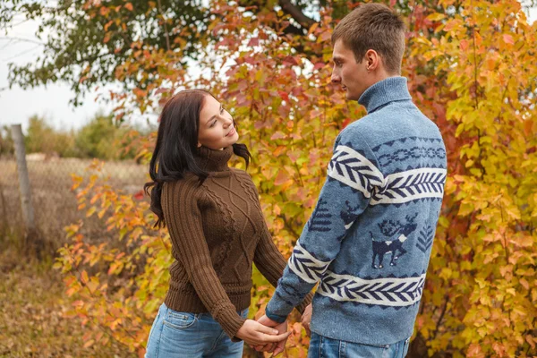 A loving couple holding hands in autumn park outdoors — Stock Photo, Image