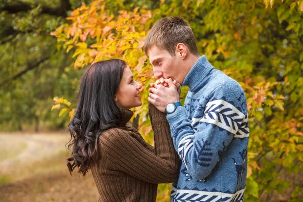 Man warms his hands girl breathing. The park outdoors — Stock Photo, Image