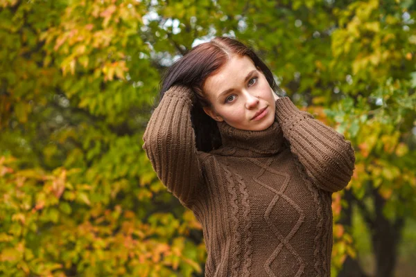 Hermosa chica en un jersey marrón en el parque de otoño —  Fotos de Stock