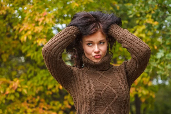 Hermosa chica en un jersey marrón posando en el parque de otoño —  Fotos de Stock