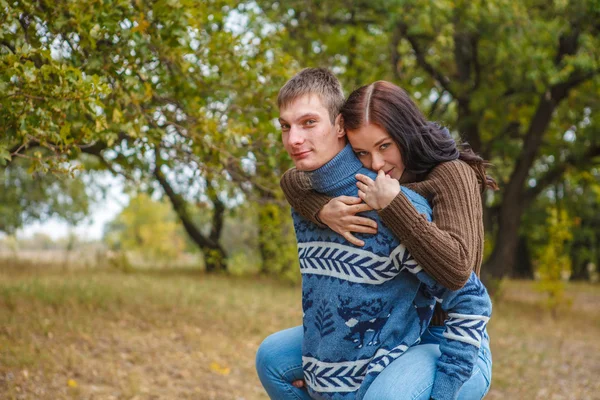 Dívka sedící na zádech chlap. Pár v lásce v parku — Stock fotografie