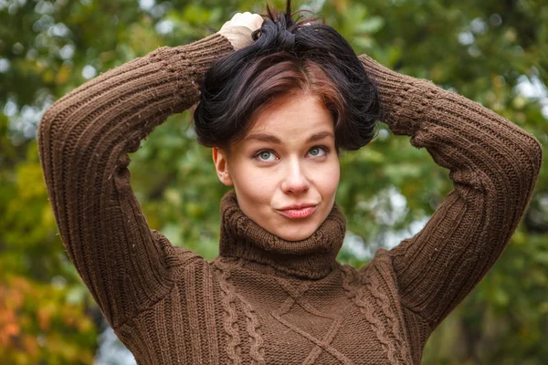 Hermosa chica en un jersey marrón posando en el parque de otoño —  Fotos de Stock