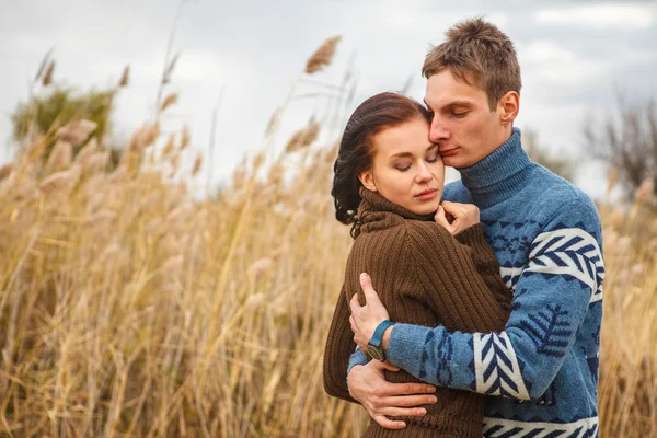 Couple embraces on the shore of the pond in the park — Stock Photo, Image