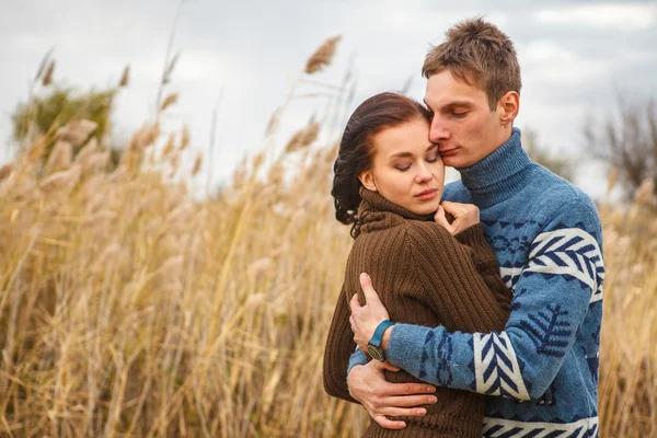 Pareja abraza en la orilla del estanque en el parque — Foto de Stock