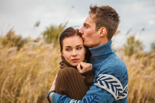 Couple embraces on the shore of the pond in the park — Stock Photo, Image