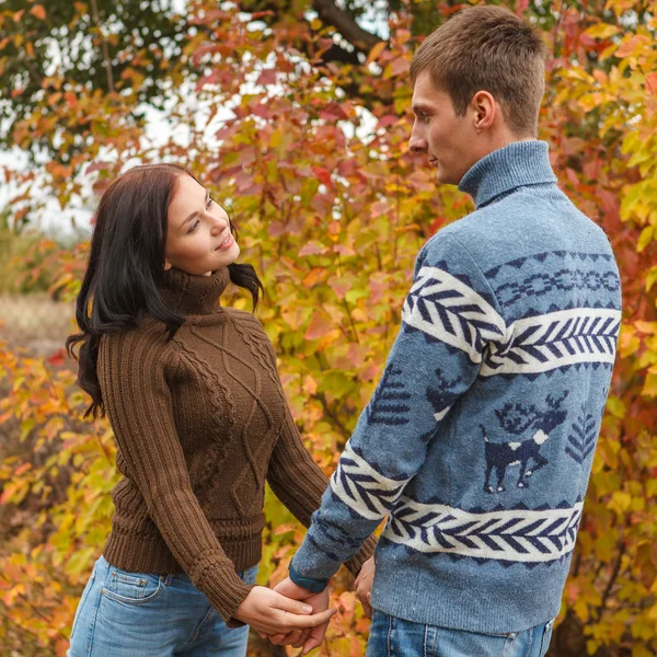 A loving couple holding hands in autumn park outdoors — Stock Photo, Image