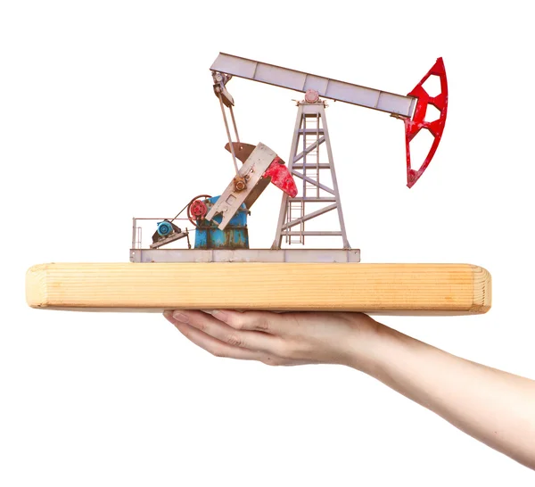 Oil pump on a wooden board on a female hand — Stock Photo, Image