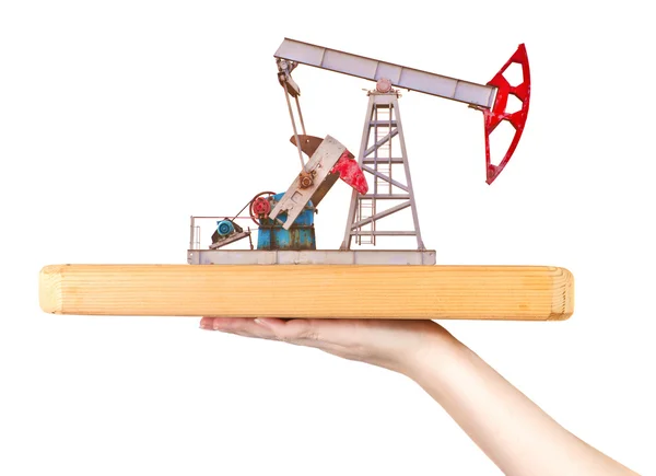 Oil pump on a wooden board on a female hand — Stock Photo, Image