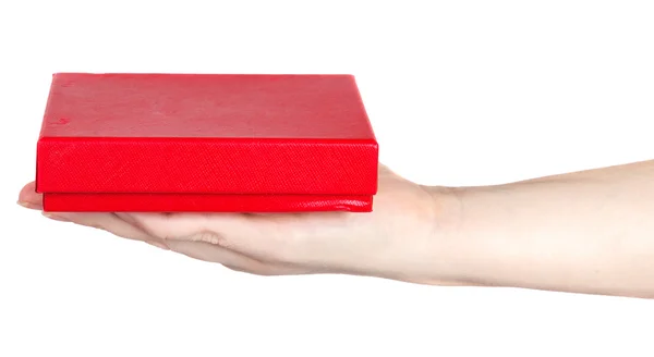 Caja roja en una mano femenina sobre un fondo blanco — Foto de Stock