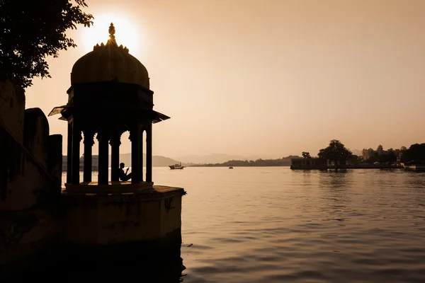 Man sitting in a Chhatri beside Pichola Lake at Sunset — Stock Photo, Image