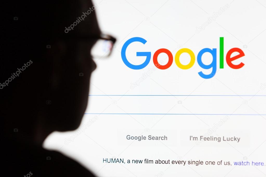 BATH, UK - SEPTEMBER 12, 2015: Close-up of the Google.com search homepage displayed on a LCD computer screen with the silhouette of a man's head out of focus in the foreground.