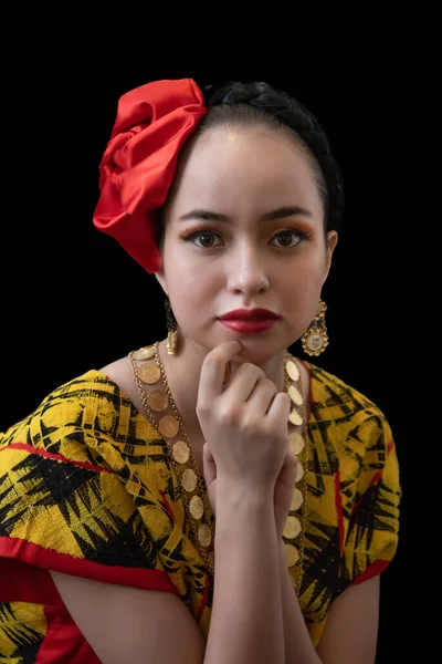 从墨西哥瓦哈卡州穿成Tehuana的拉丁女人 戴着红色的花朵 金项链和耳环 黑色的背景 微笑和沉思 — 图库照片