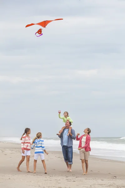 Familia padres niña niños volando cometa en playa —  Fotos de Stock
