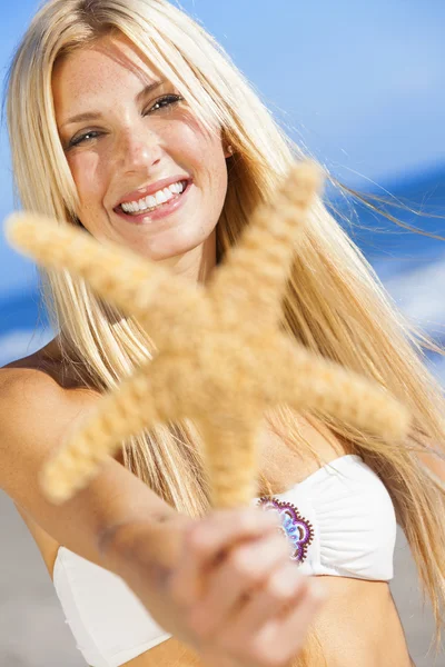 Mulher bonita menina em biquíni com estrela do mar na praia — Fotografia de Stock