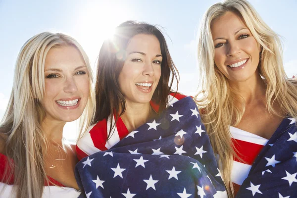 Three Young Women Wrapped in American Flags on a Beach — Stok fotoğraf