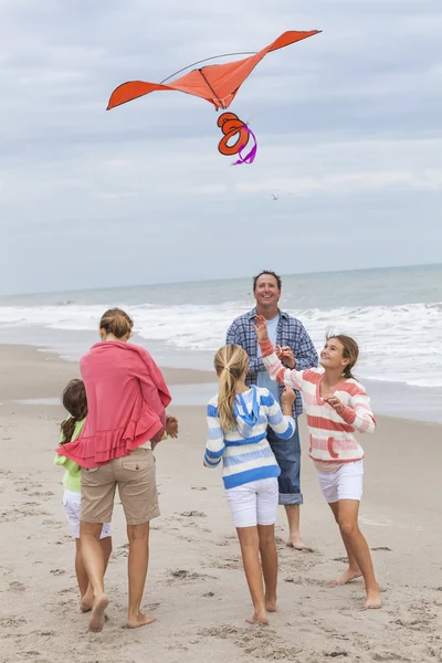 Família pais menina crianças voando pipa na praia — Fotografia de Stock