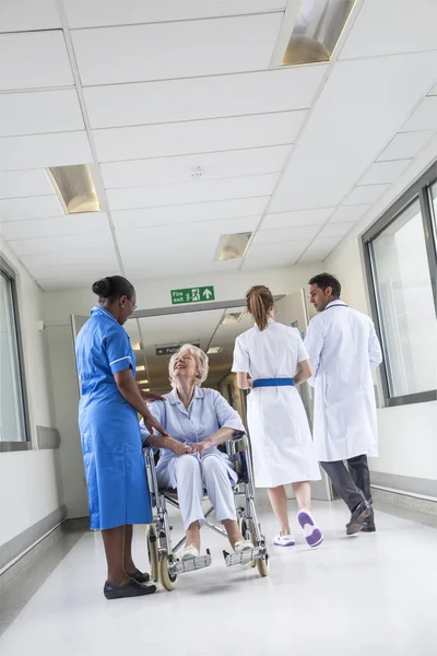 Senior vrouwelijke patiënt in rolstoel & verpleegkundige in het ziekenhuis — Stockfoto