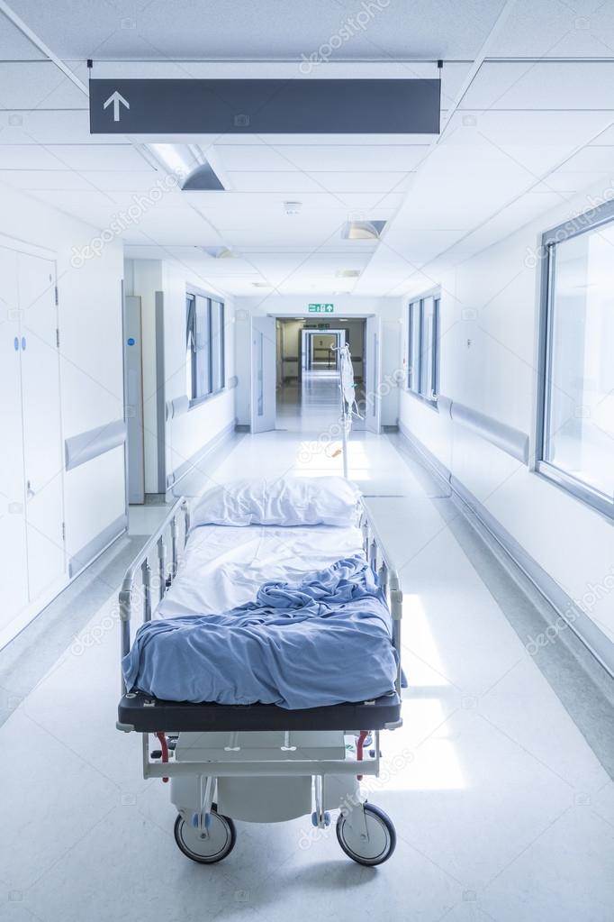 Empty Stretcher Bed Gurney in Hospital Corridor Stock Photo by