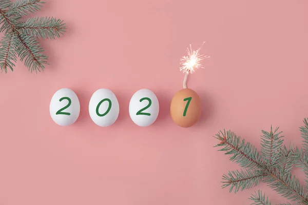 Mutlu yıllar 2021. Yumurtaların üzerine pembe arka planda 2021 numara yazılmış. Noel ve Yeni Yıl. Yanmış fileto ve ateş dolu son yumurta..