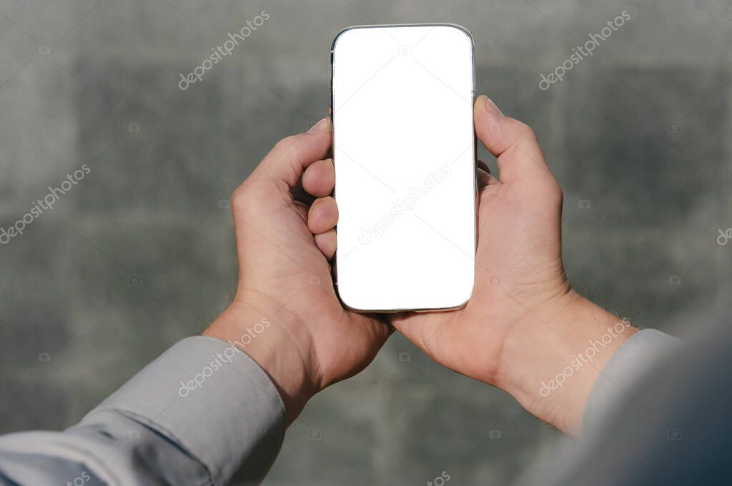 Close up, mock up smartphone, in hands, of a person. against the background of a concrete wall