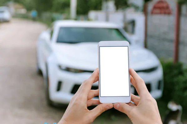 Akıllı Telefonu Kız Ellerinde Taklit Et, Arka planda Beyaz bir araba