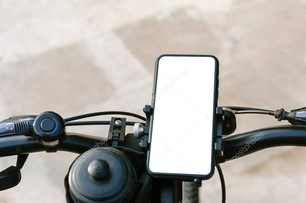 Close-up, mockup of a smartphone on the handlebars of a bicycle. Against the background of concrete and asphalt
