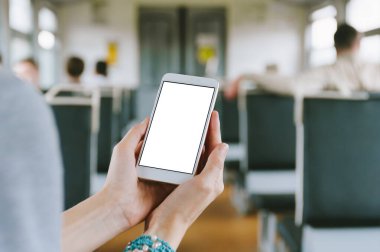 Akıllı telefon taklidi yap, kadın eline yakın çekim yap. Bir tren vagonunun arka planında
