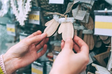 Mağazadaki kız yeni yılın dekoratif süslemelerini elinde tutuyor.