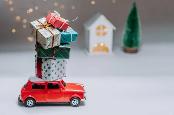 Czerwony Samochód Tle Lasu Domu Przyniesie Świąteczne Prezenty Noworoczne — Zdjęcie stockowe