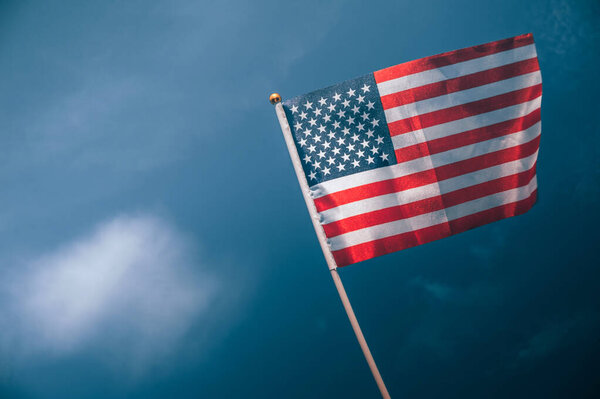 Американский флаг на фоне пасмурного неба