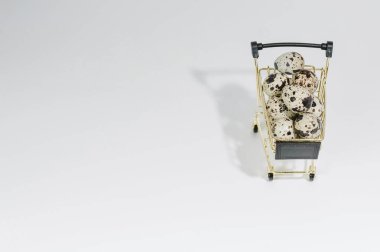 El arabasındaki bıldırcın yumurtalarına yakın çekim. Hafif bir arkaplanda. Paskalya ve yumurta satışı konsepti