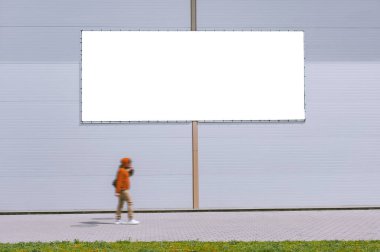 Gri bir duvarın önünde bir adamın yürüdüğü sokak afişinin maketi.