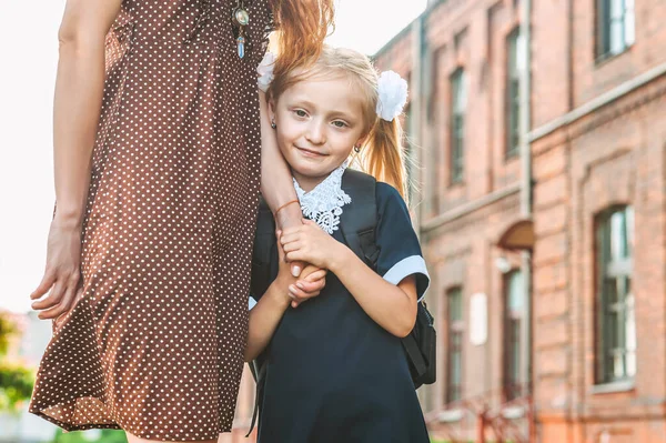 学校での初日 母親が小学校1年生の少女を率いて — ストック写真